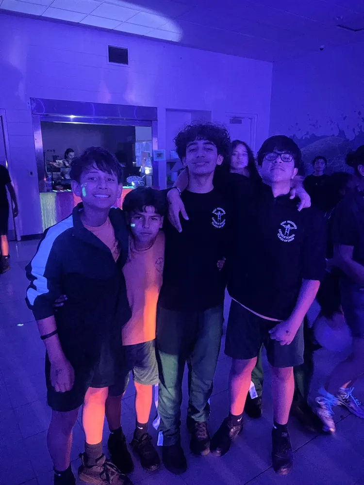 Holy Redeemer students posing together under blacklights at the glow-in-the-dark dance party